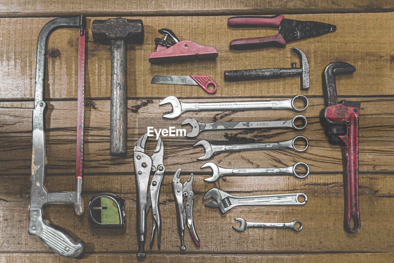 HIGH ANGLE VIEW OF TOOLS ON WOODEN TABLE