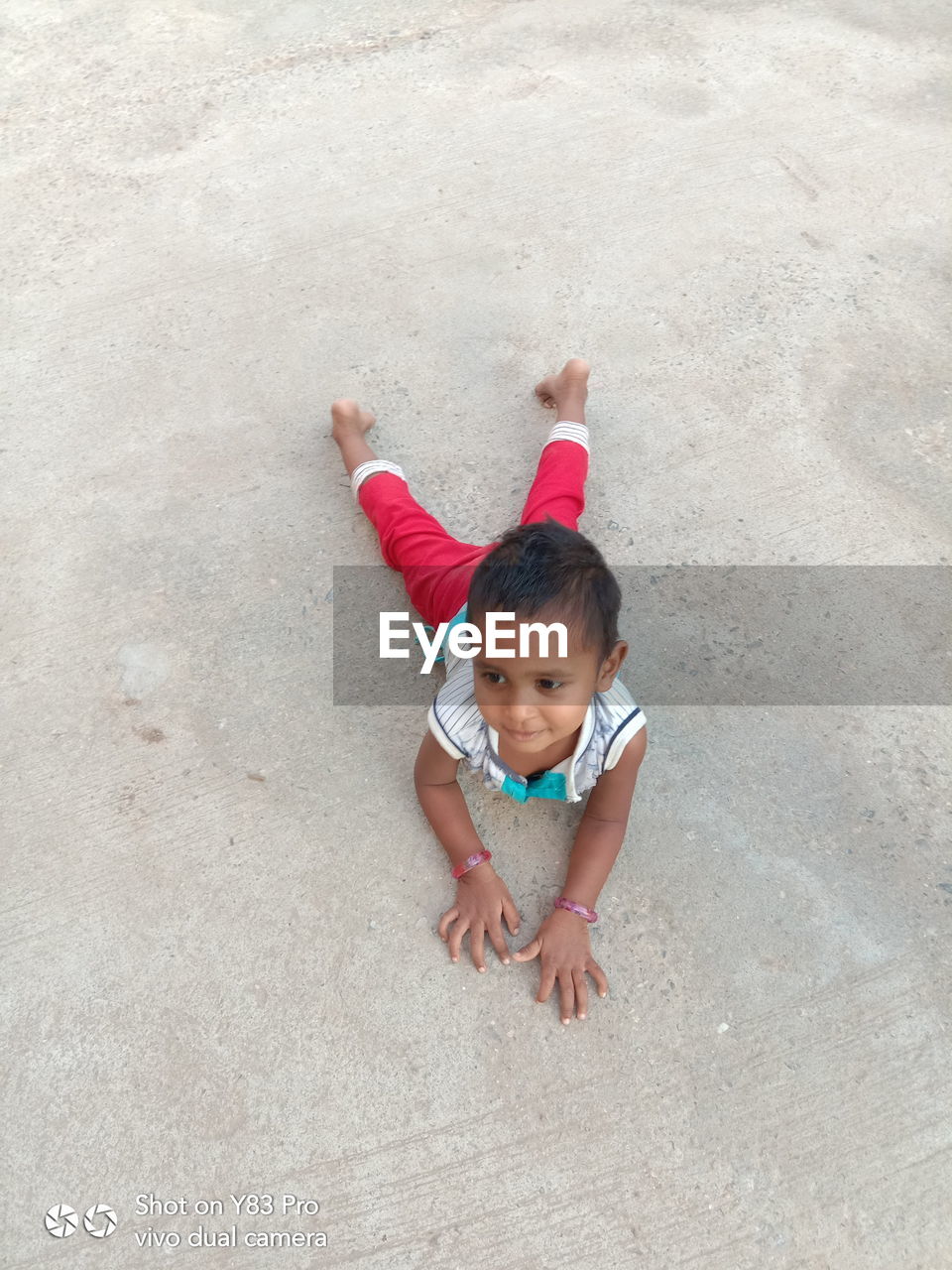 HIGH ANGLE PORTRAIT OF CUTE BABY GIRL ON BEACH