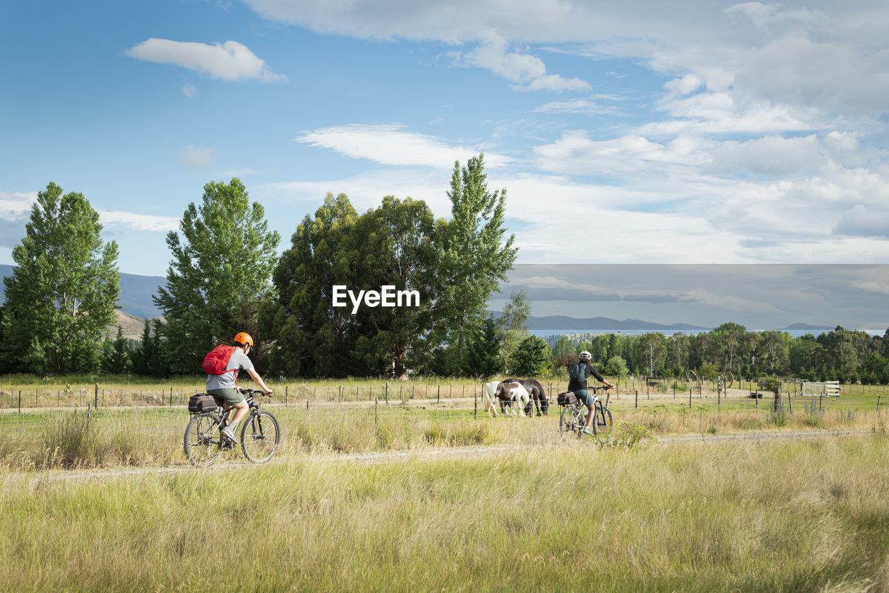 MEN RIDING BICYCLE ON FIELD