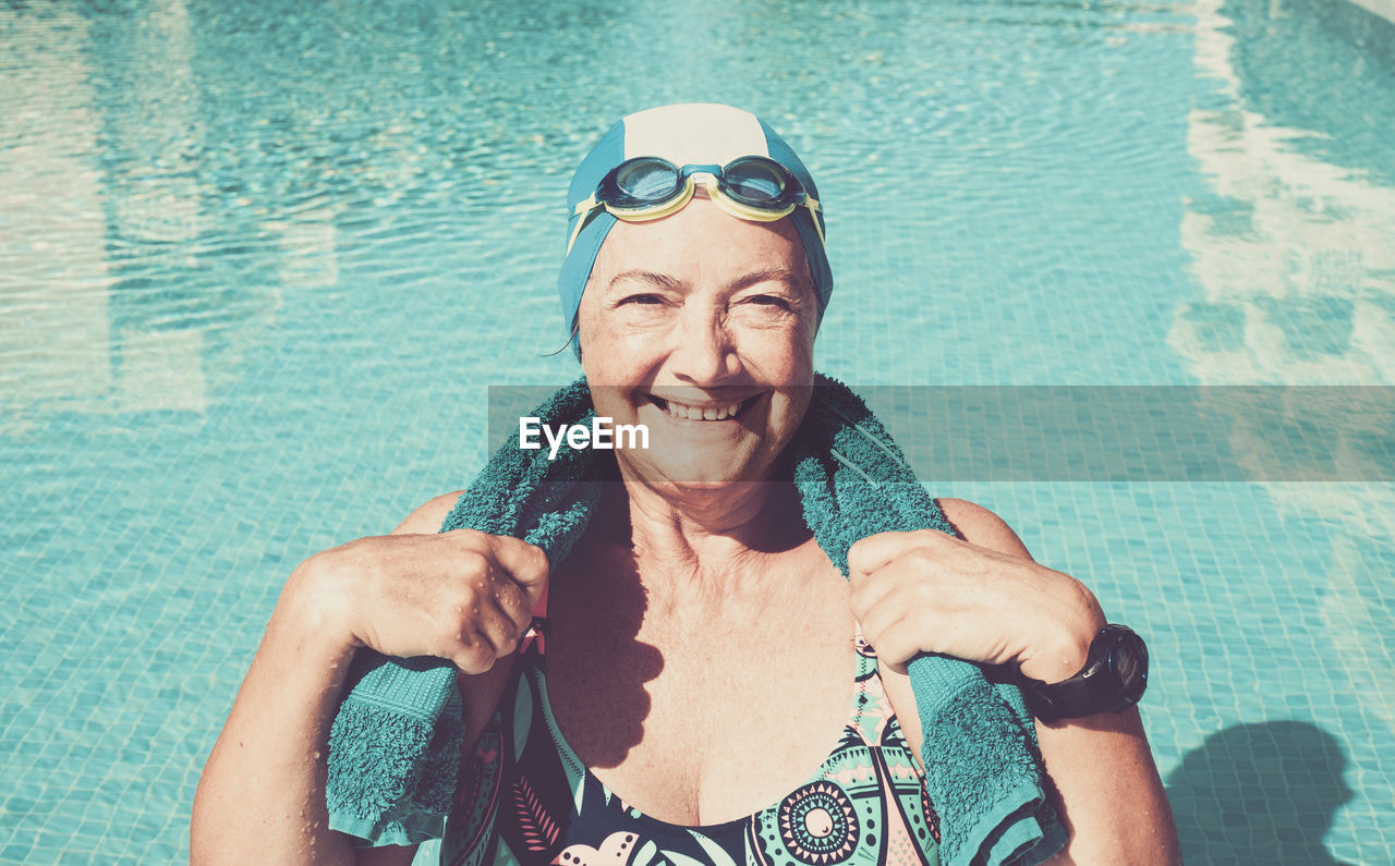 Portrait of smiling senior woman in swimming pool