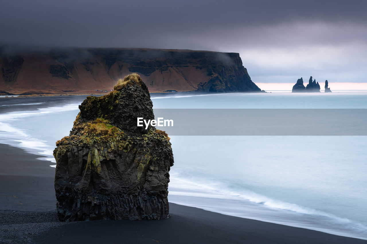 Looking to reynisfjara black sand beach and reynisdrangar during sunrise on a stormy morning