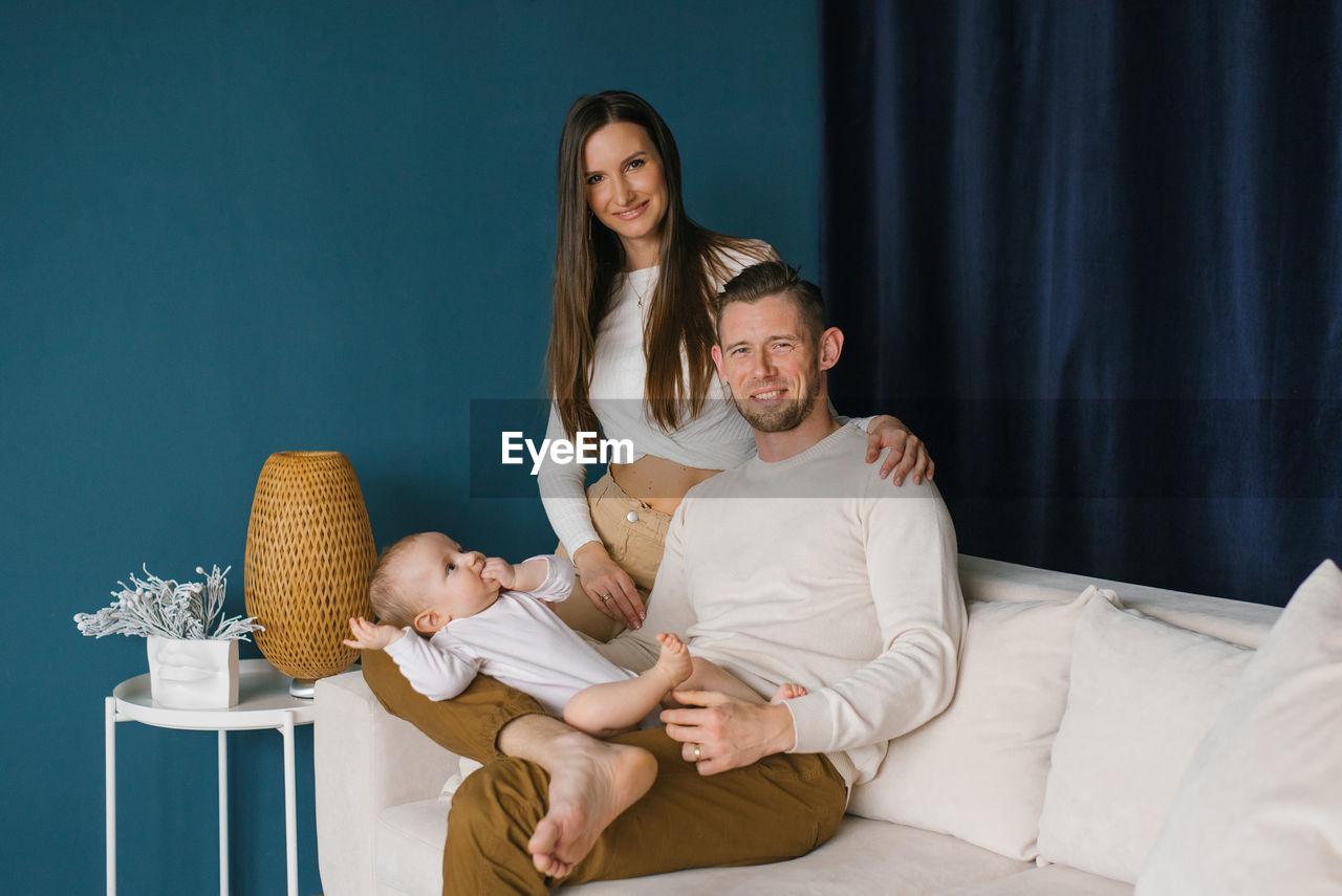 Happy family, mother and father sitting on the couch and happy together