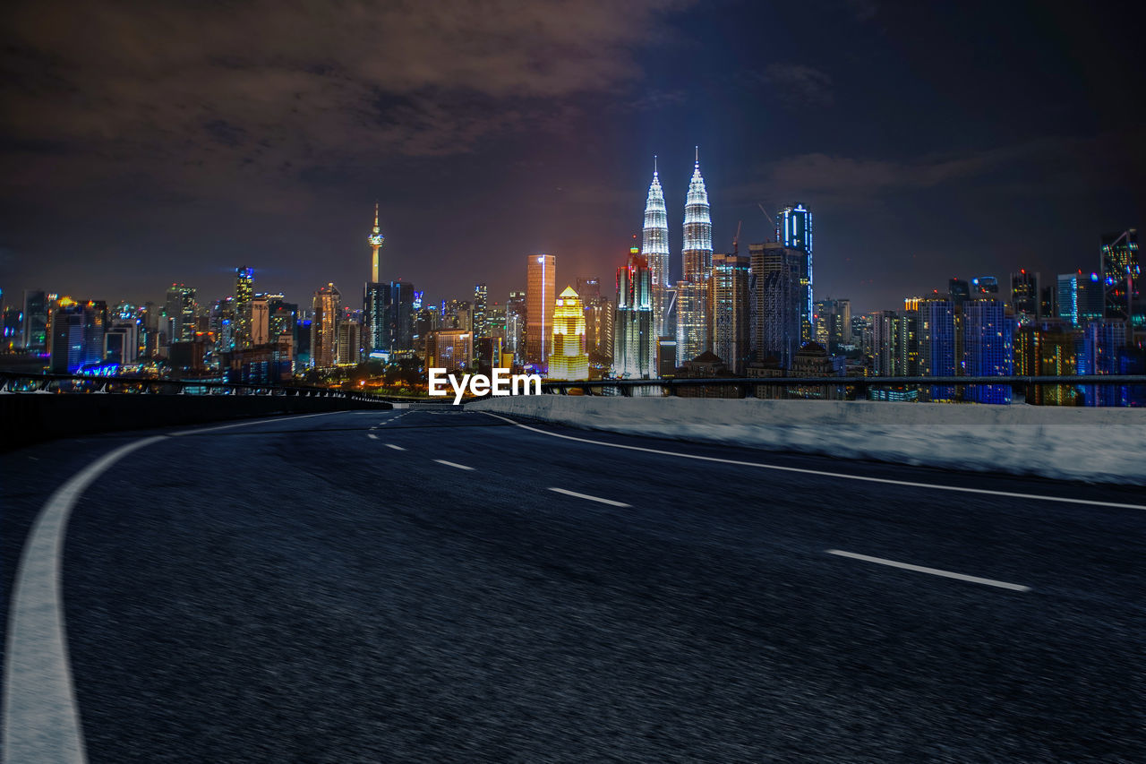 Empty curve highway with a view of kuala lumpur city.