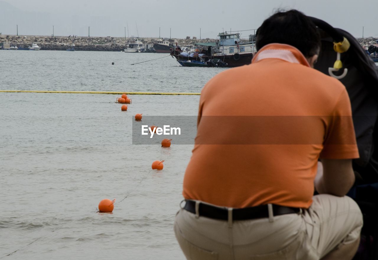 REAR VIEW OF A MAN WITH BALL IN WATER