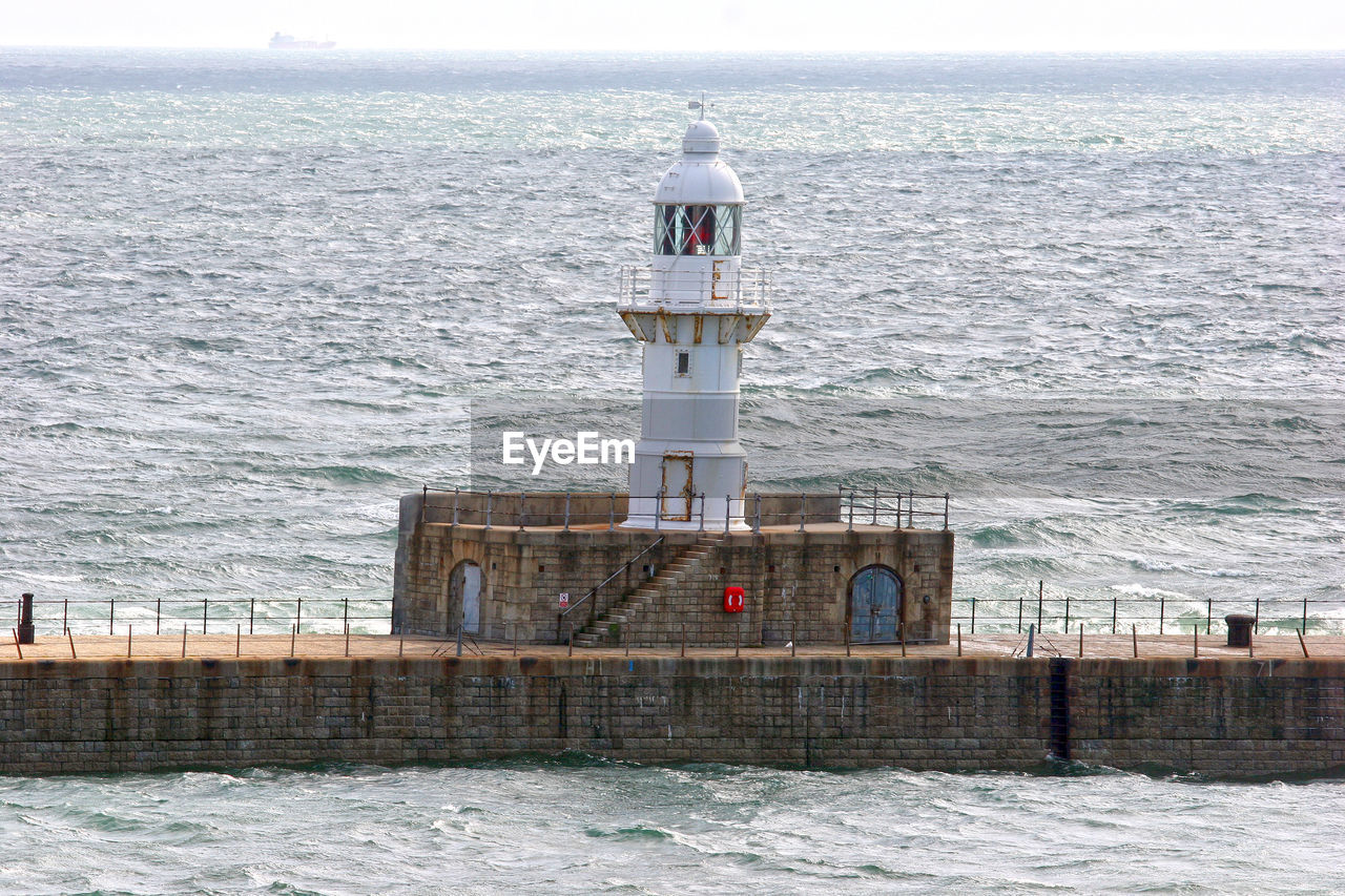 Lighthouse on jetty in sea