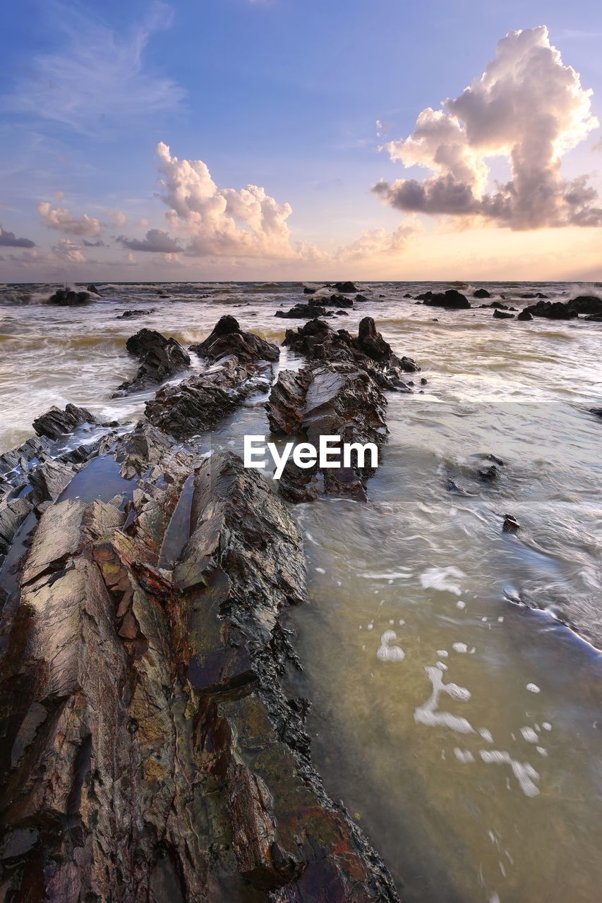 Rocky seascape with sunrise background