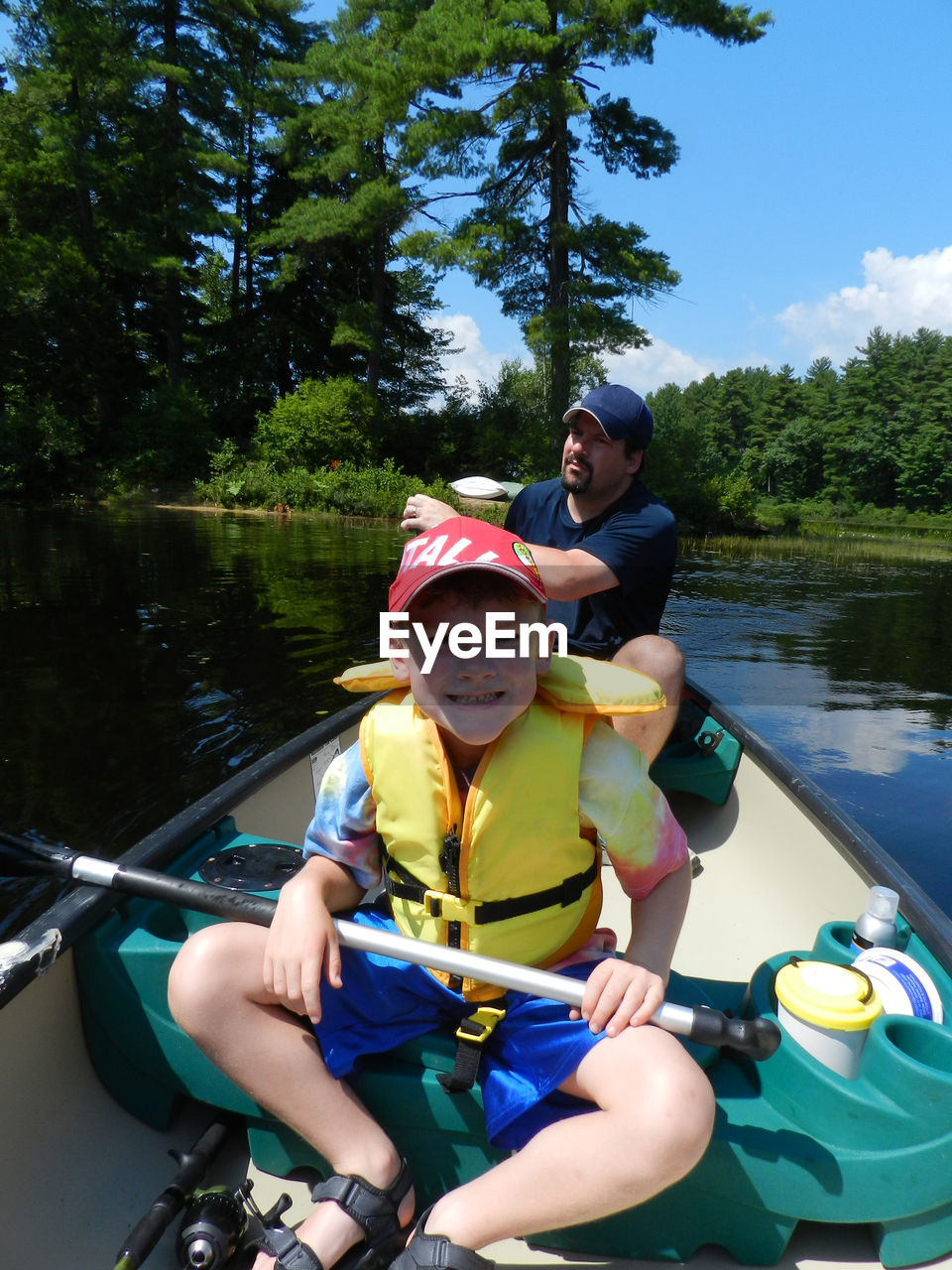 Happy boy with father canoeing in lake