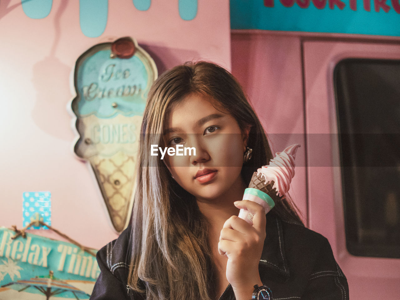 Portrait of young woman holding ice cream