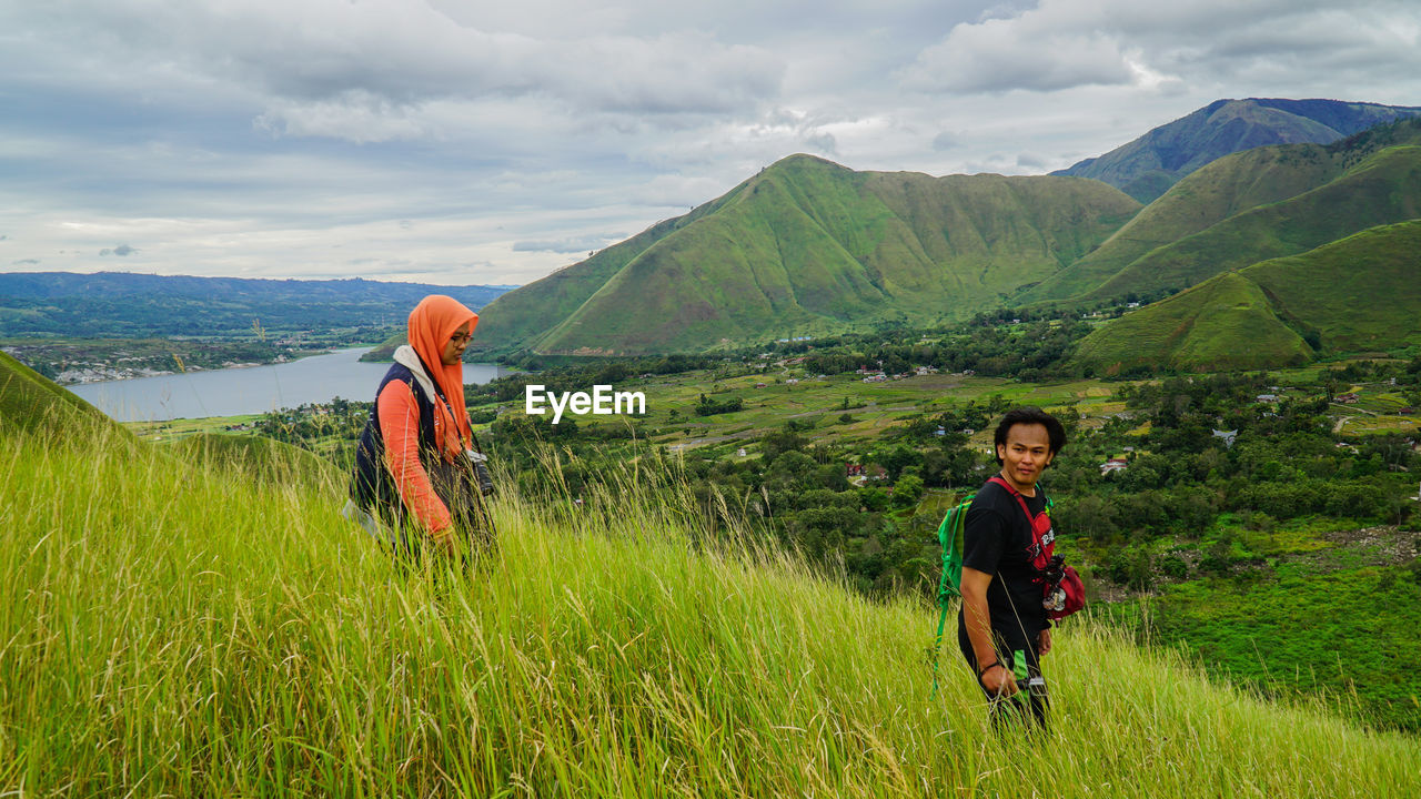 SIBLINGS STANDING ON MOUNTAIN