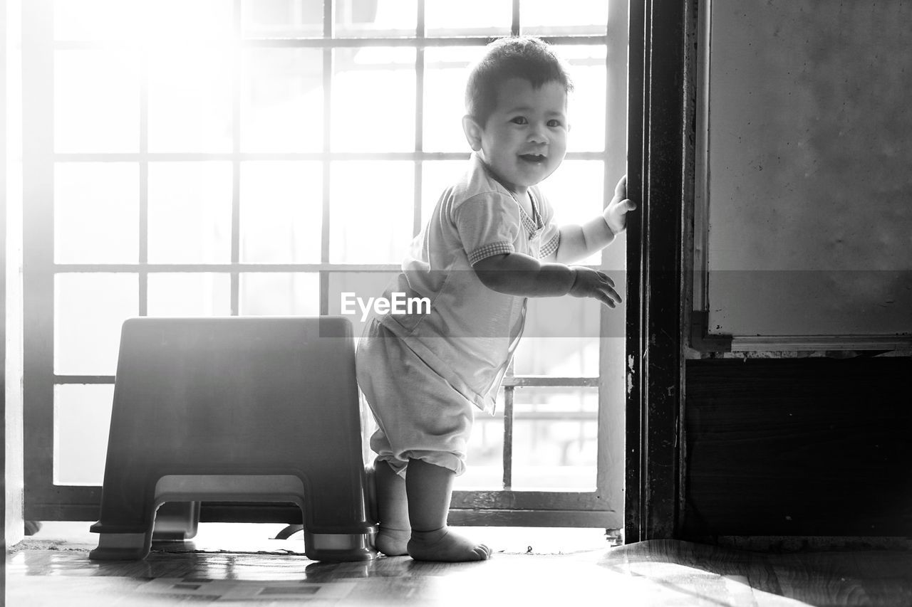 Baby boy standing at doorway