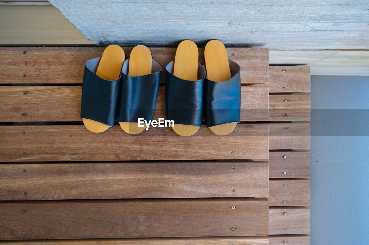 HIGH ANGLE VIEW OF MULTI COLORED SHOES ON WOOD