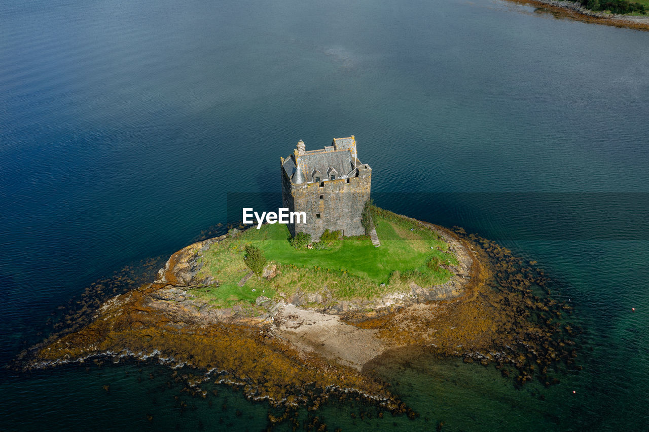 water, sea, history, architecture, the past, reflection, terrain, built structure, high angle view, coast, nature, tower, no people, travel destinations, aerial photography, building exterior, travel, day, building, land, outdoors, castle, cliff, ocean, aerial view, beach, old, fort