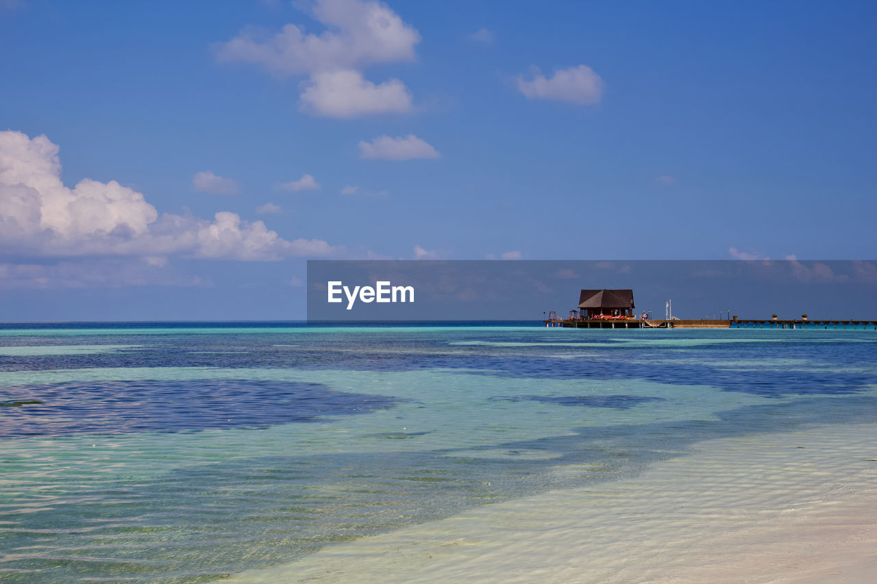 water, sea, sky, horizon, body of water, shore, ocean, land, beach, cloud, nature, scenics - nature, beauty in nature, coast, vacation, wave, horizon over water, travel, blue, sand, travel destinations, bay, wind wave, tranquility, architecture, tranquil scene, motion, transportation, no people, holiday, outdoors, tourism, day, trip, nautical vessel, hut, seascape, idyllic, built structure, tropical climate, mode of transportation, environment