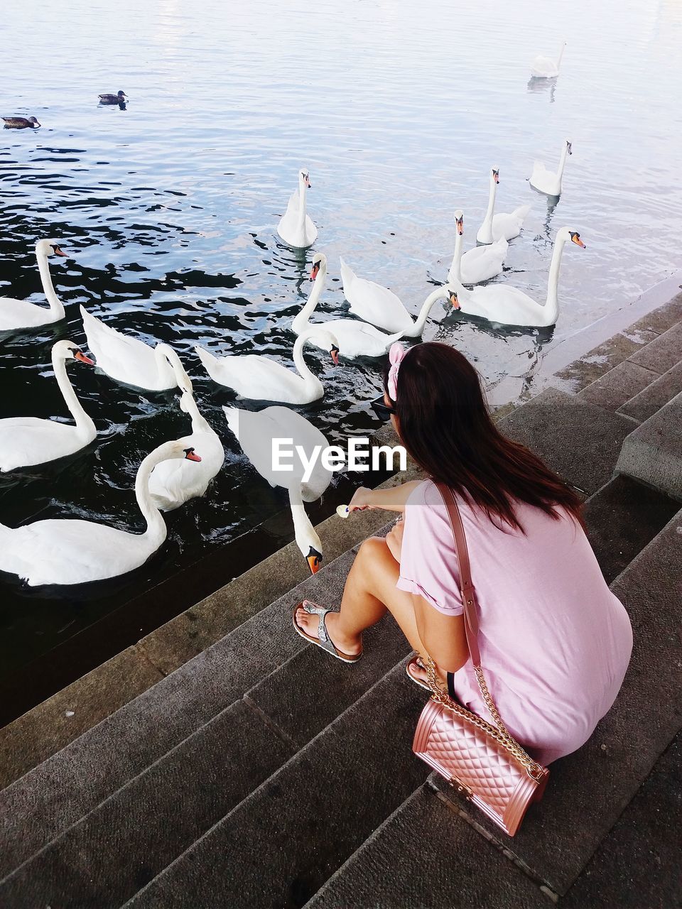 HIGH ANGLE VIEW OF WOMAN SITTING AT LAKE