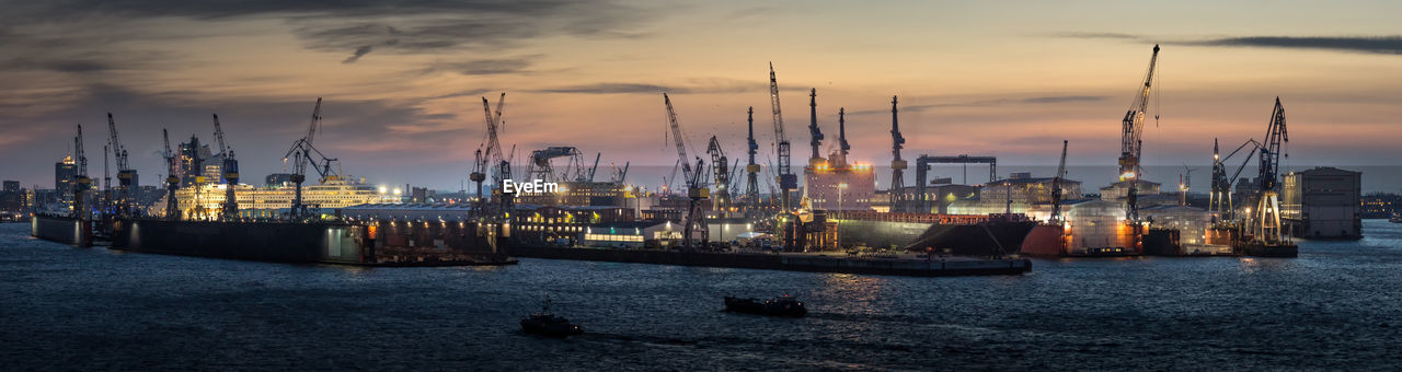 Boats moored at harbor against sky during sunset