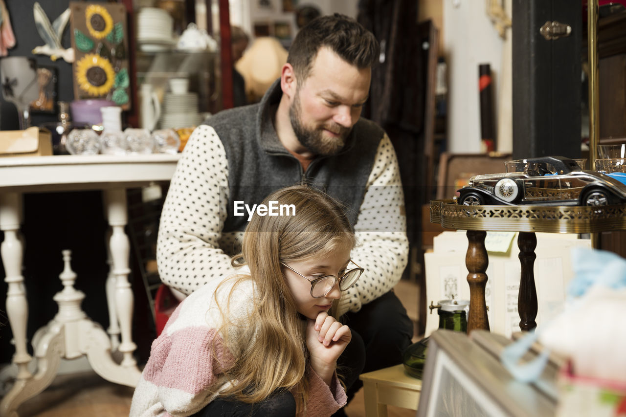 Father with daughter doing shopping in antique shop