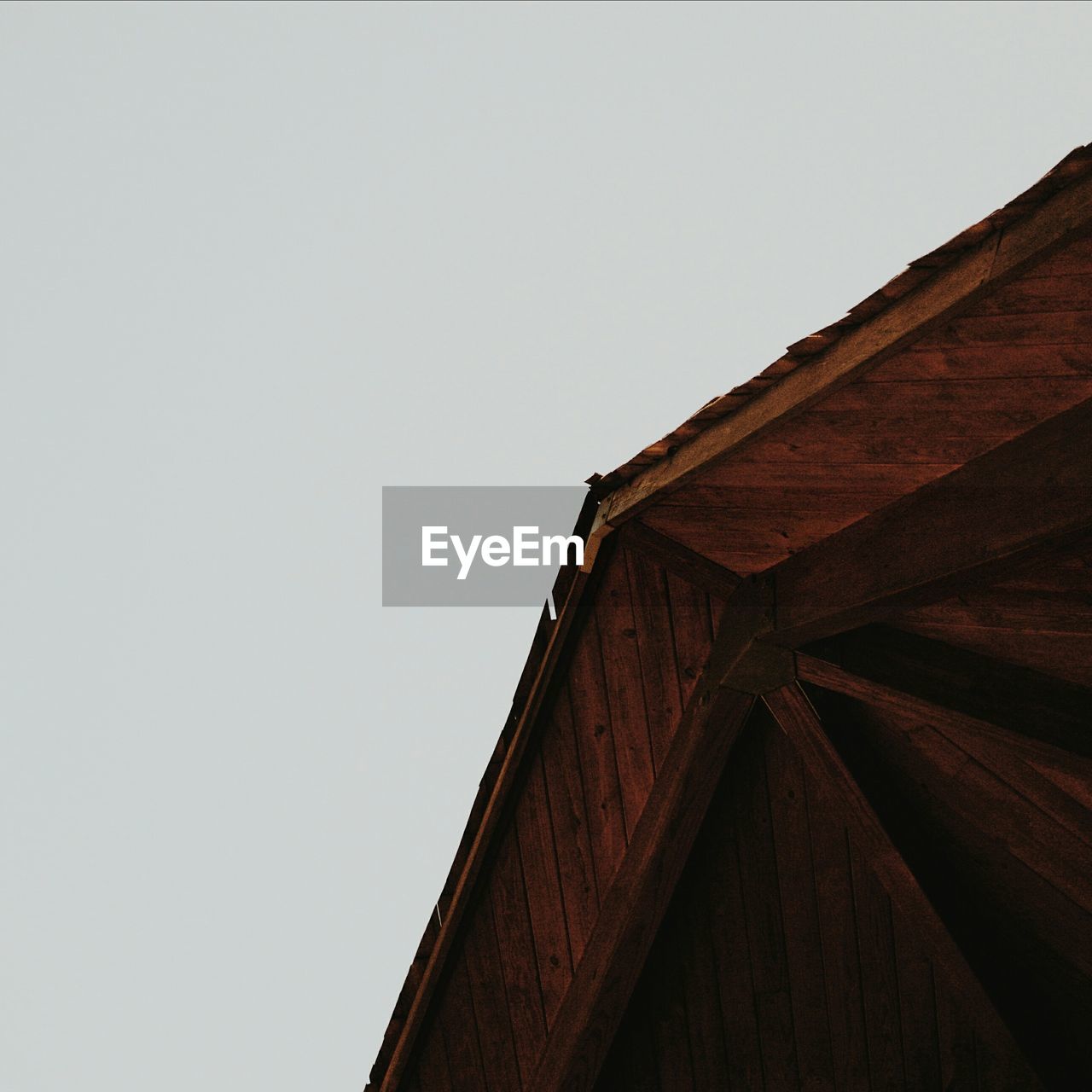 Low angle view of barn roof against clear sky