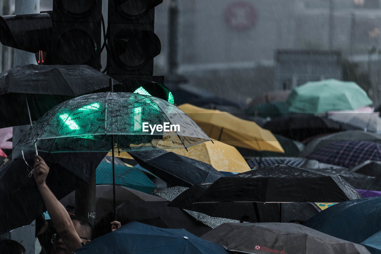 Close-up of man holding umbrella in rain