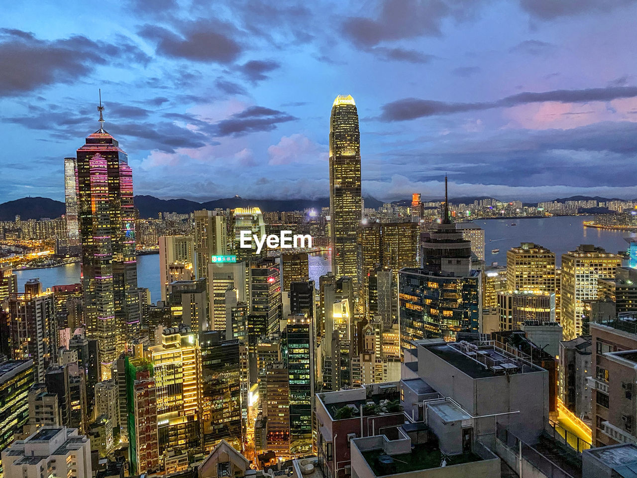 Illuminated modern buildings in city against sky