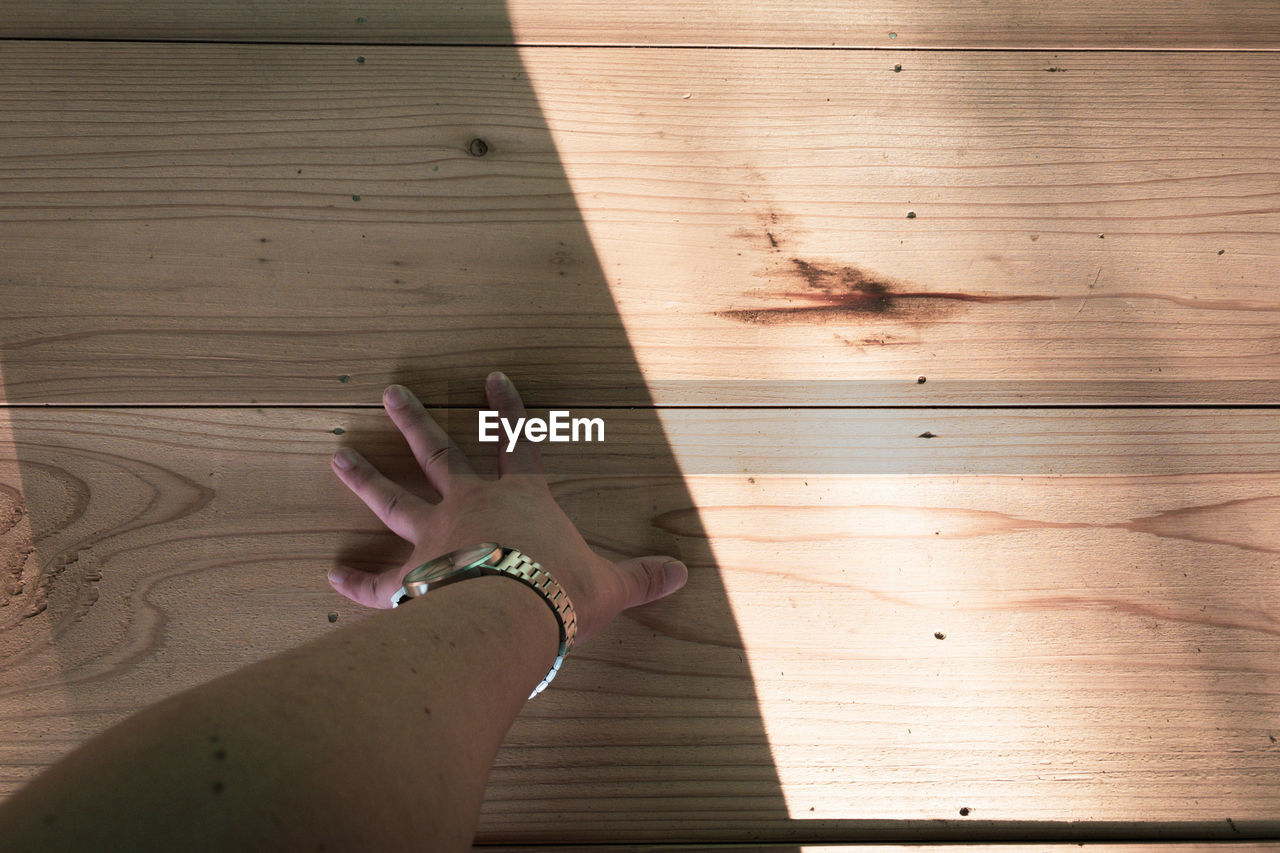 HIGH ANGLE VIEW OF HAND ON TABLE