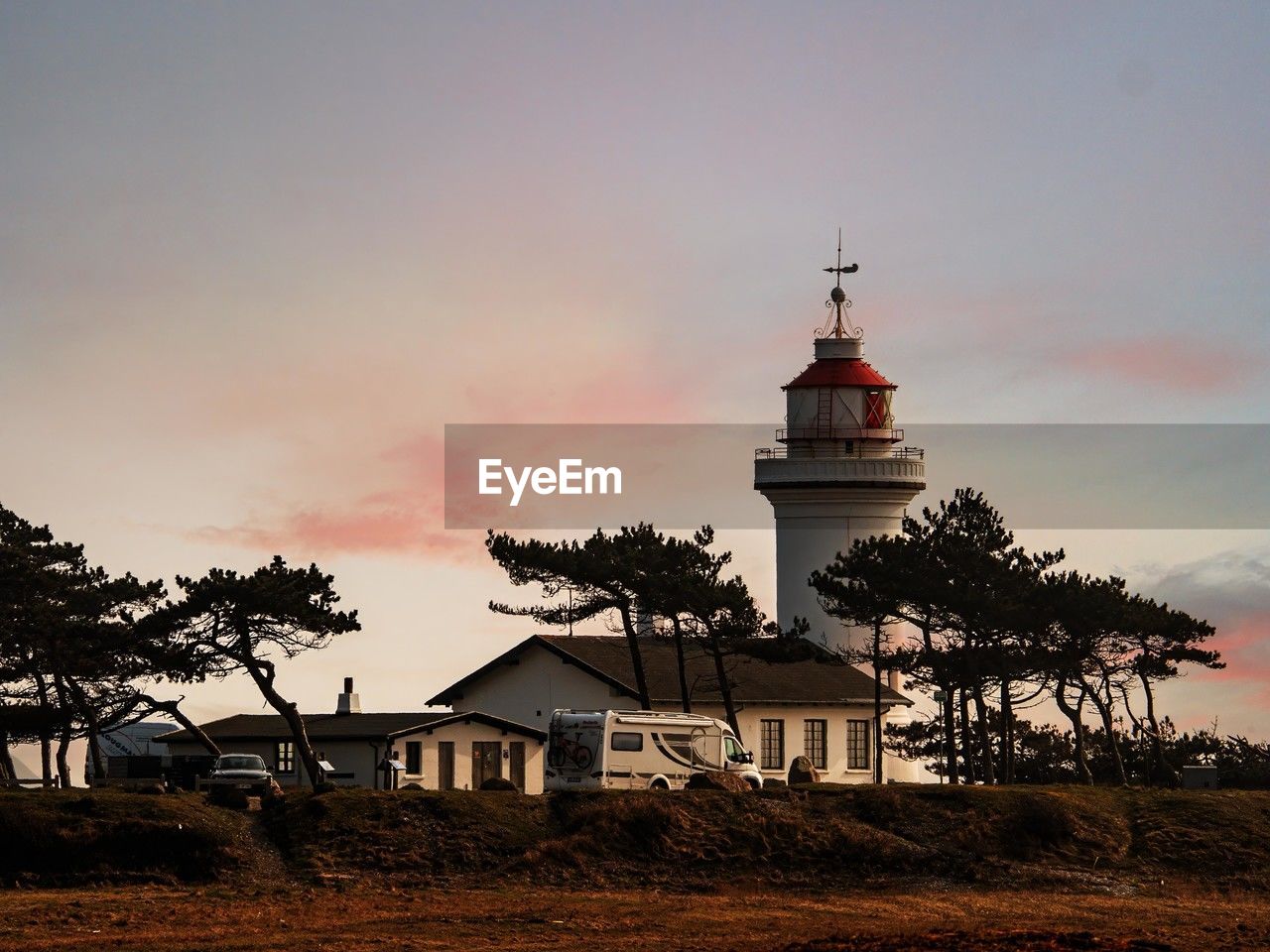 Lighthouse by sea against sky