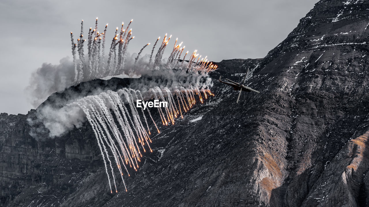 Swiss air force super puma helicopter shooting flares at the axalp life fire demonstration 2021