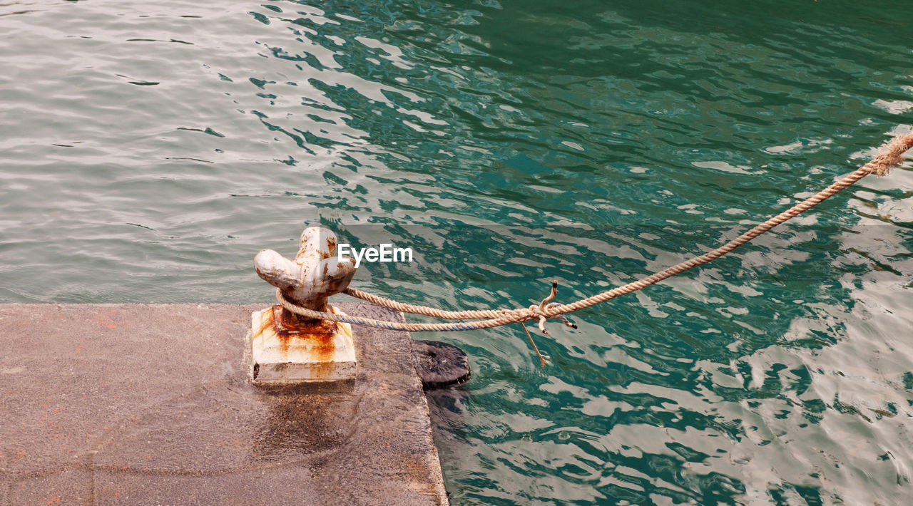 High angle view of rope around cleat on pier over lake