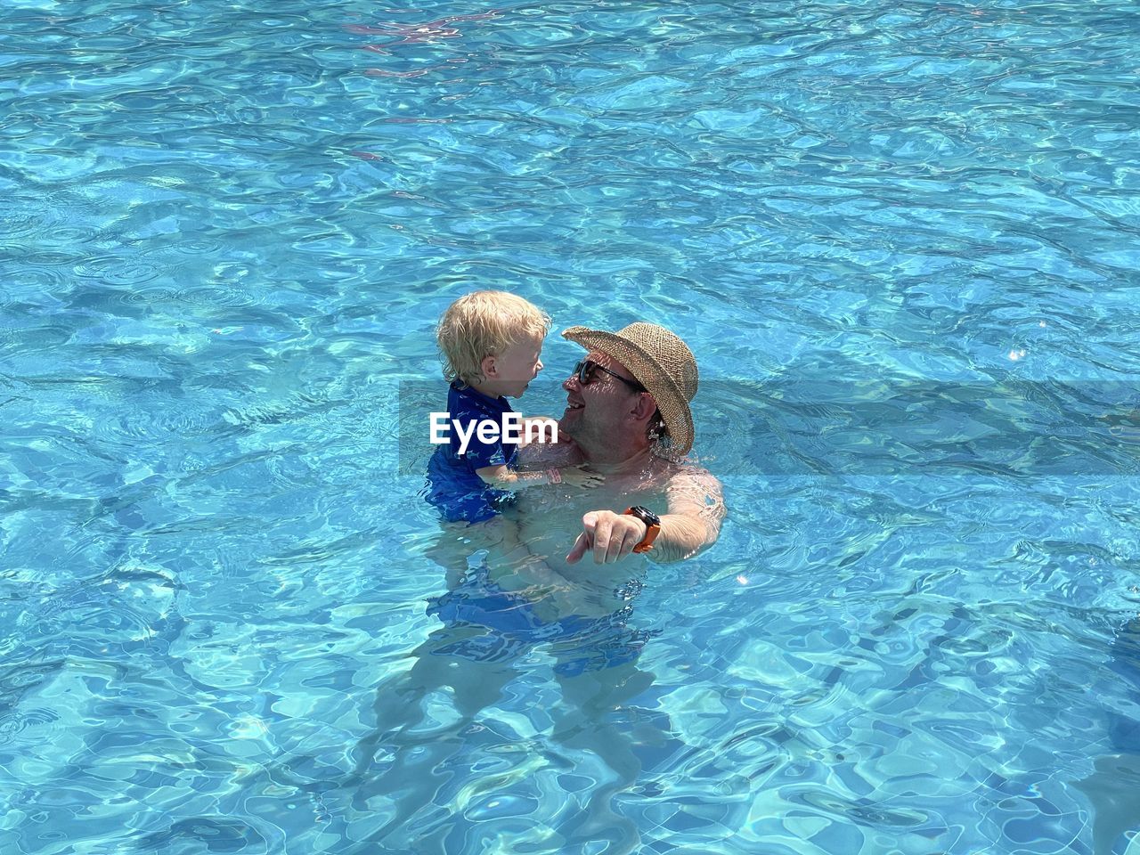Father is teaching his son swimming 