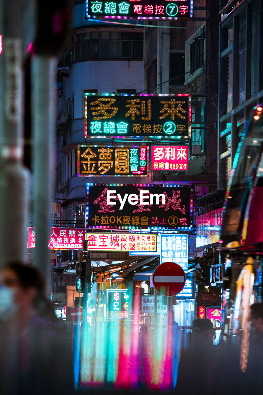 Illuminated text on street in city at night