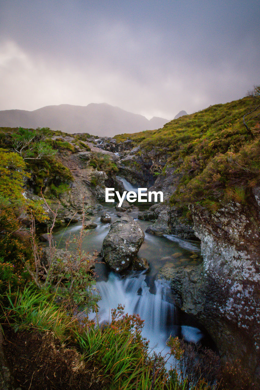 Scenic view of river amidst mountains against sky