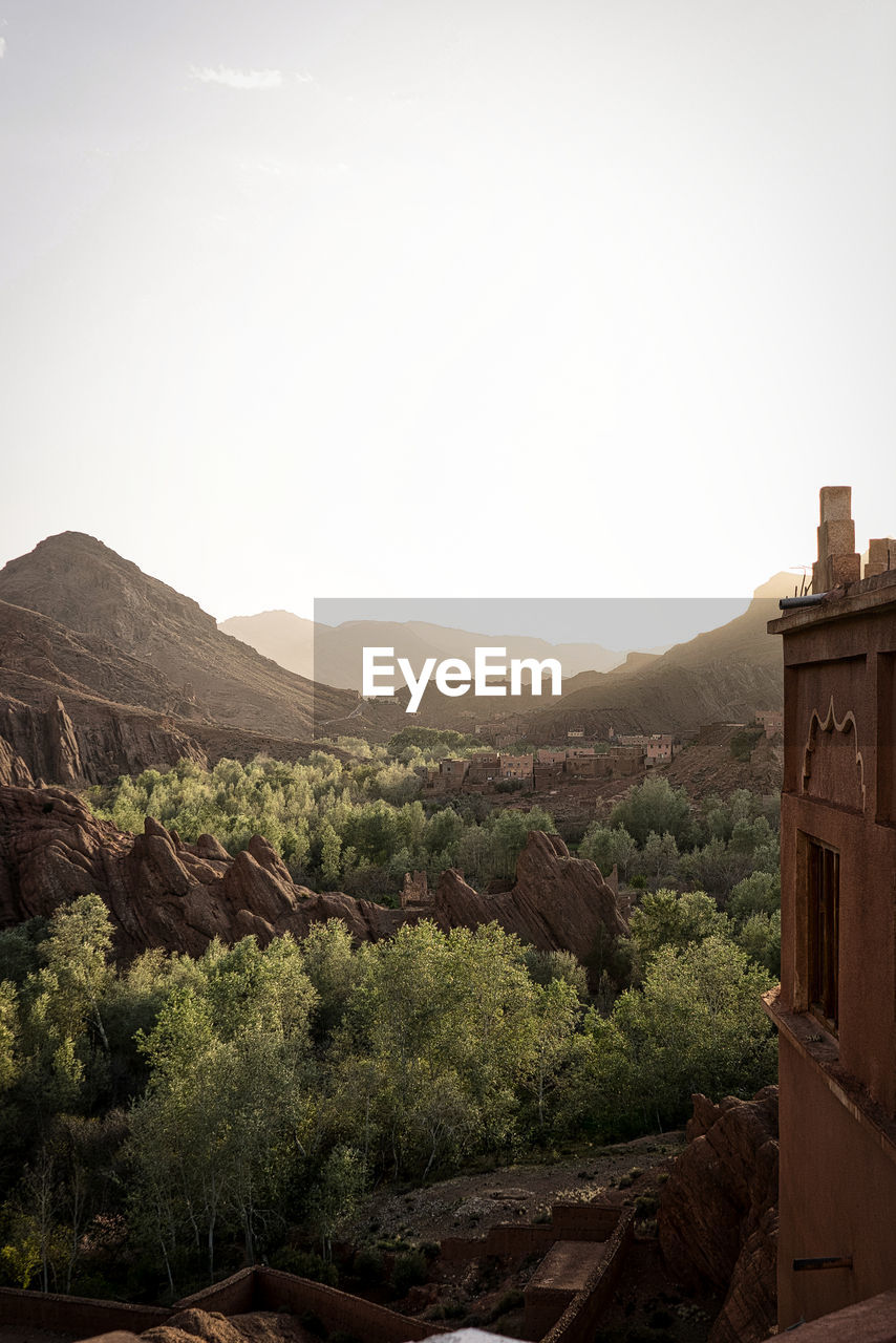 Scenic view of mountains and buildings against clear sky