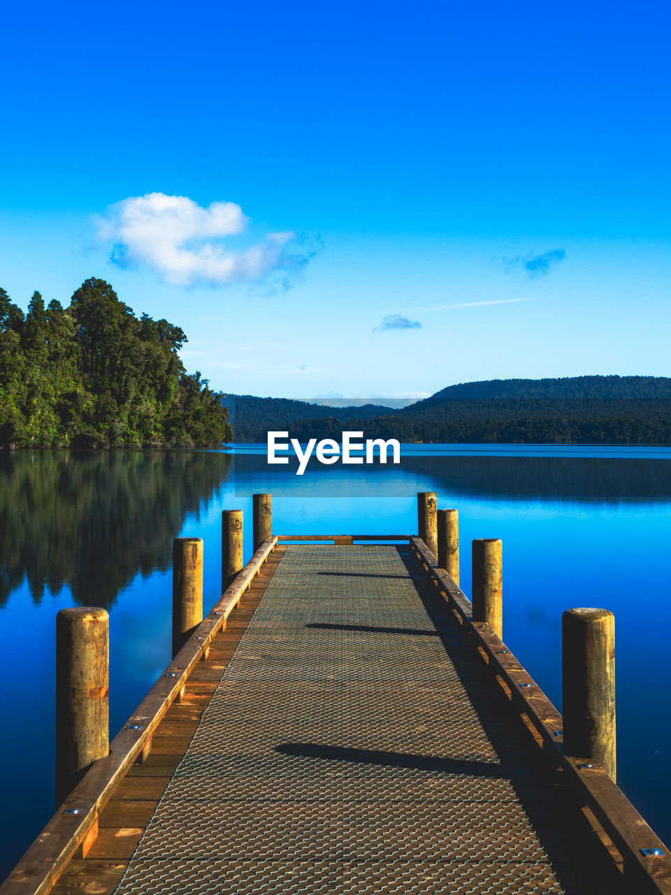 water, sky, reflection, horizon, sea, scenics - nature, tranquility, nature, beauty in nature, tranquil scene, blue, pier, shore, jetty, dusk, land, wood, bay, no people, tree, landscape, body of water, ocean, cloud, beach, environment, travel destinations, coast, the way forward, reservoir, morning, idyllic, mountain, outdoors, architecture, plant, travel, sunlight, summer, footpath, non-urban scene, diminishing perspective, trip, vacation, holiday, boardwalk, island, day, tourism, dock, relaxation, clear sky, lagoon