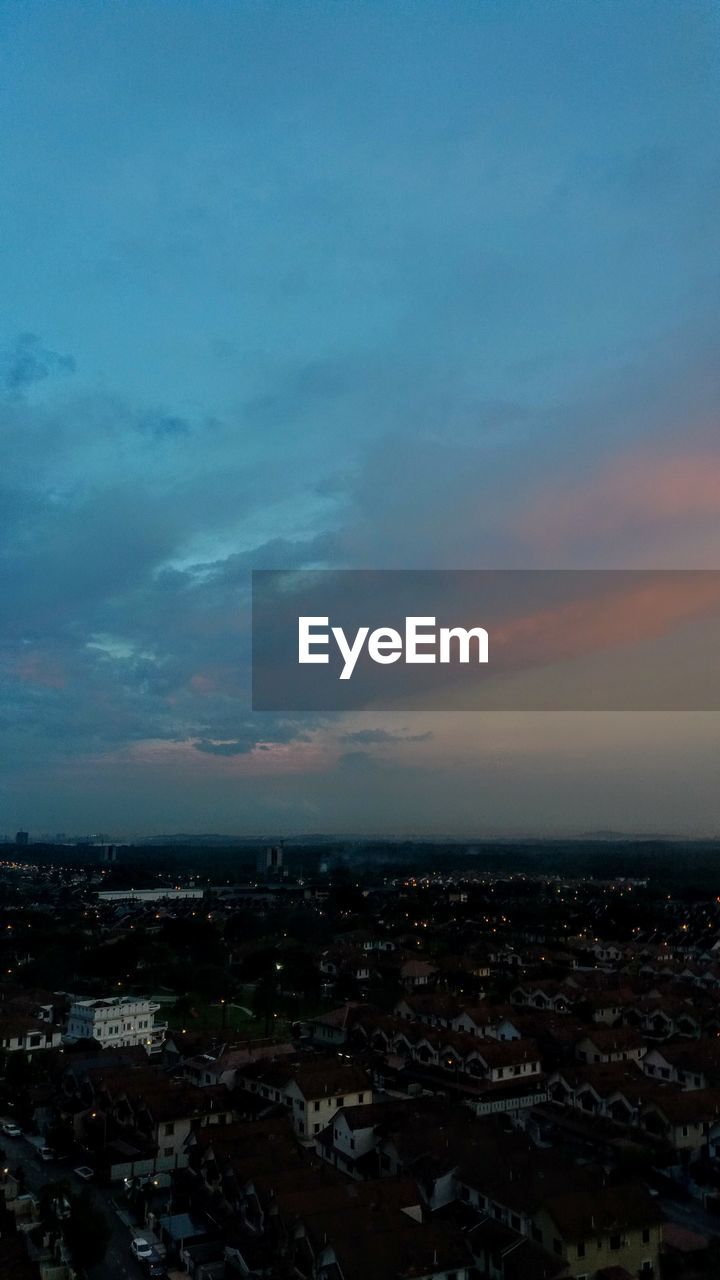 HIGH ANGLE VIEW OF ILLUMINATED CITY AGAINST SKY