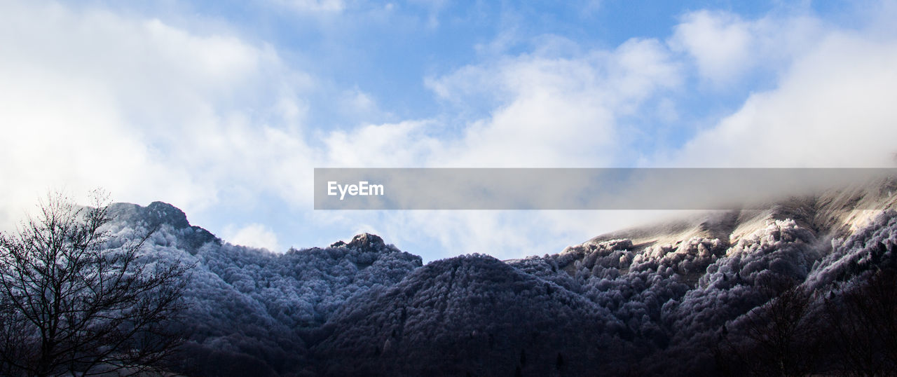 PANORAMIC VIEW OF SNOWCAPPED MOUNTAINS AGAINST SKY