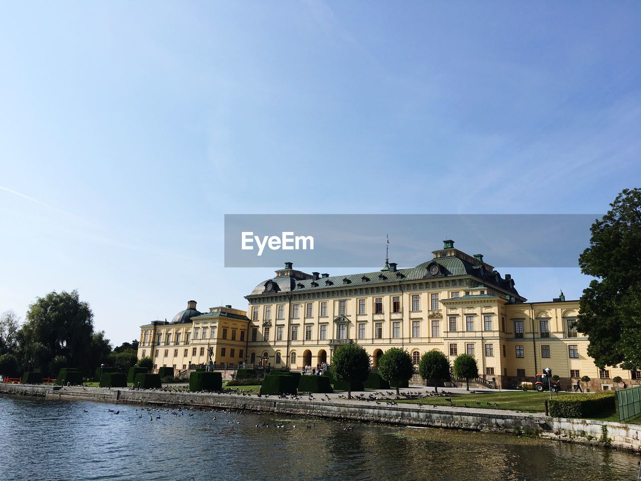 BUILDING BY RIVER AGAINST SKY