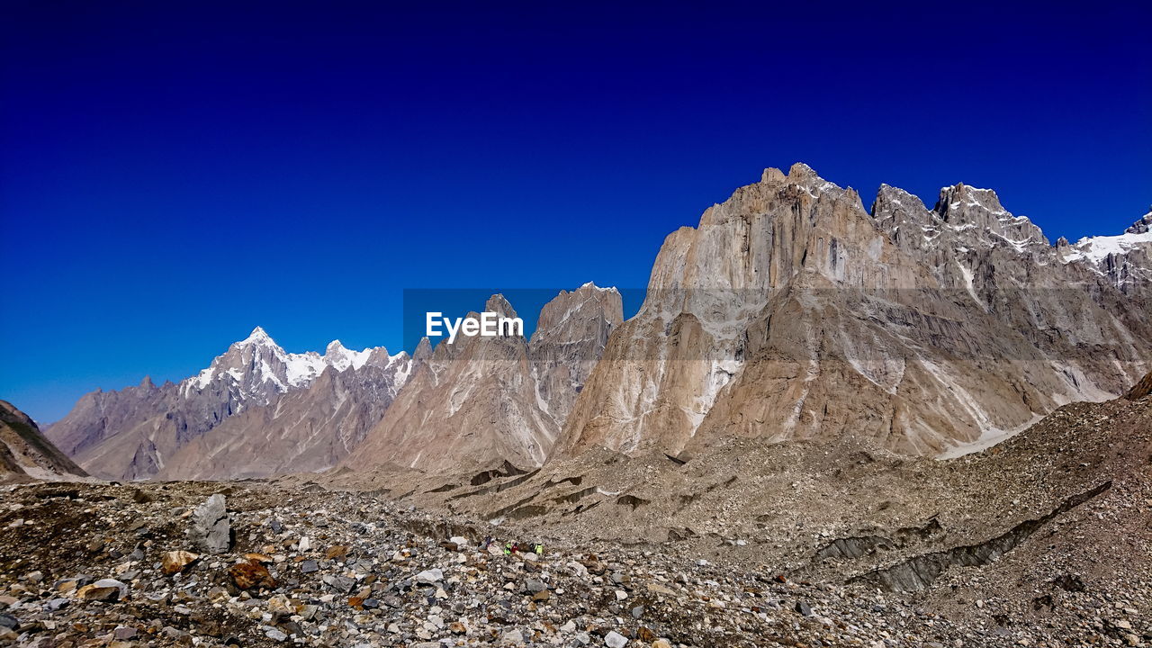 Scenic view of snowcapped mountains against clear blue sky