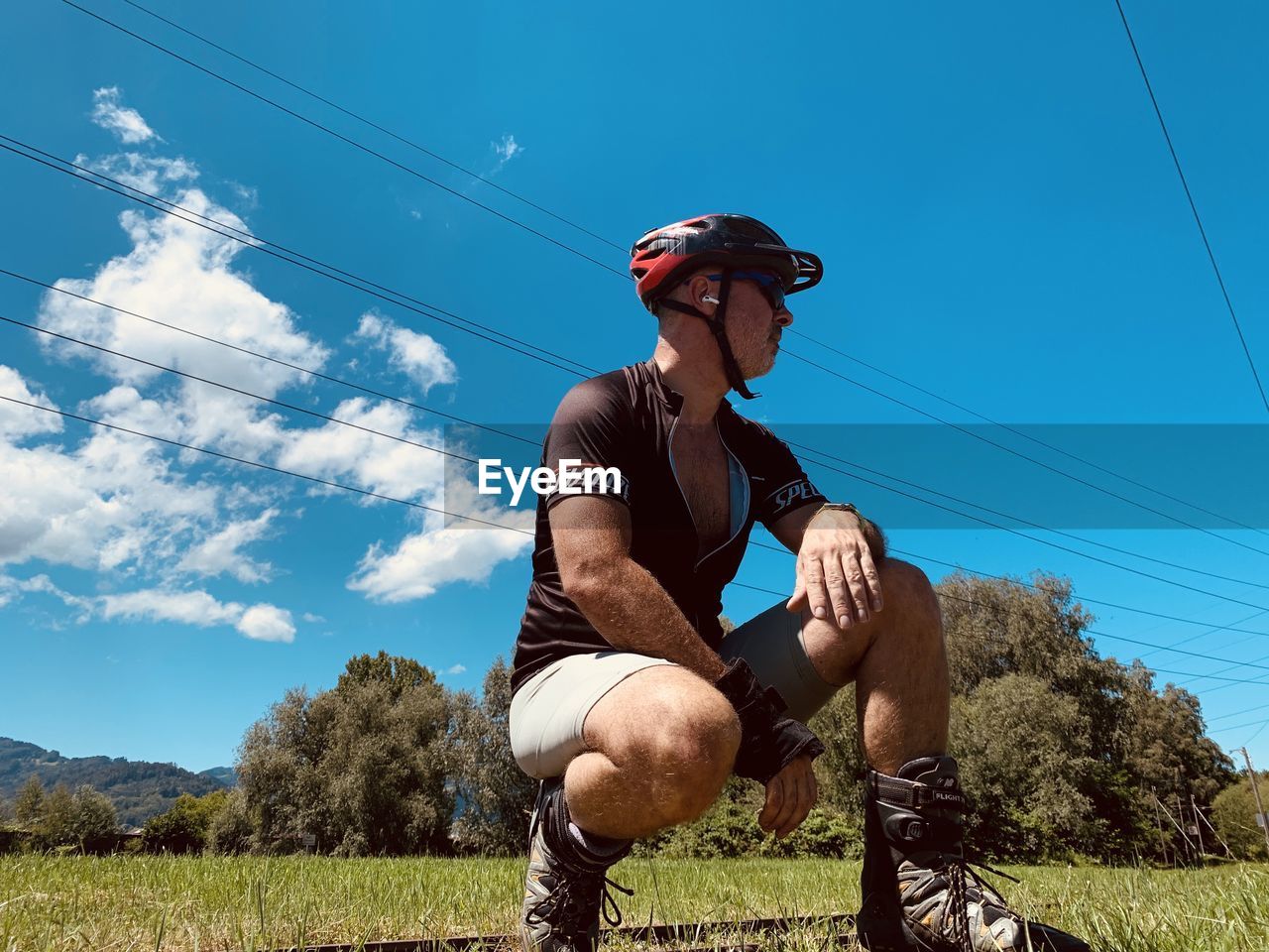 LOW ANGLE VIEW OF MAN WEARING SUNGLASSES AGAINST SKY AND TREES