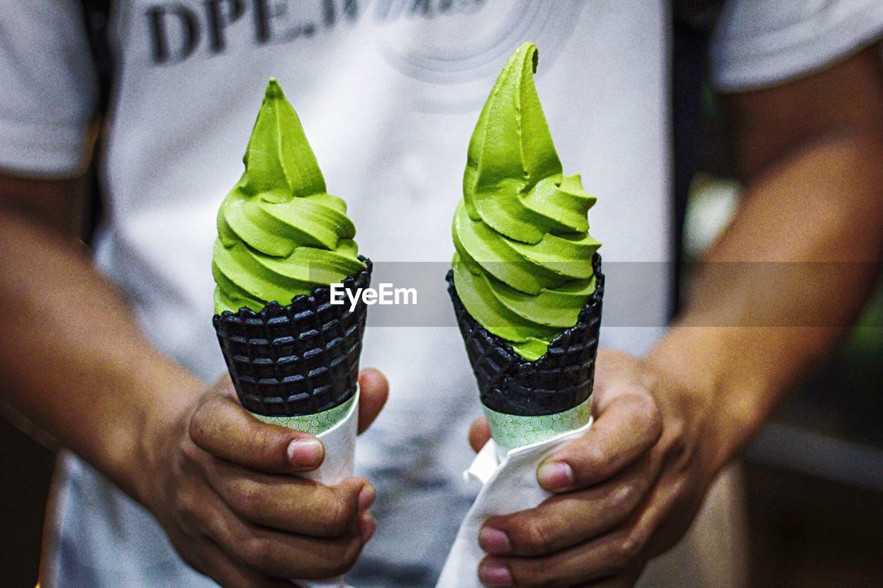 Midsection of man holding ice creams