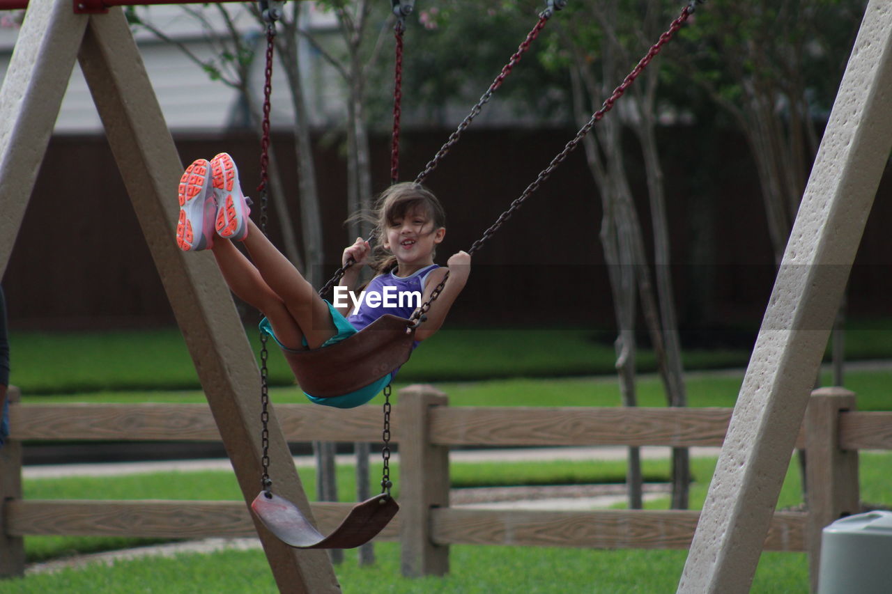 Girl enjoying swing at playground