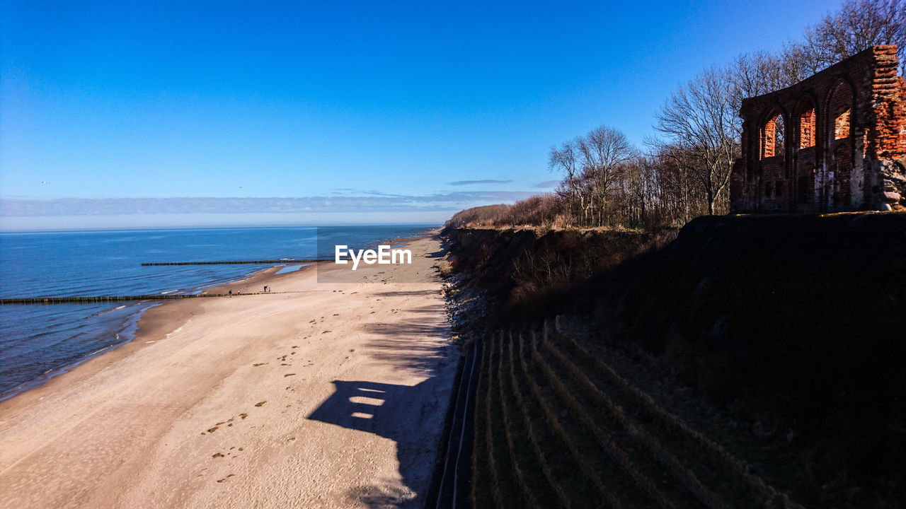 Scenic view of beach against clear blue sky