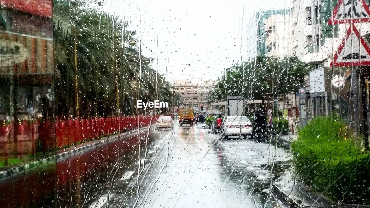 Road seen through wet window during rainy season