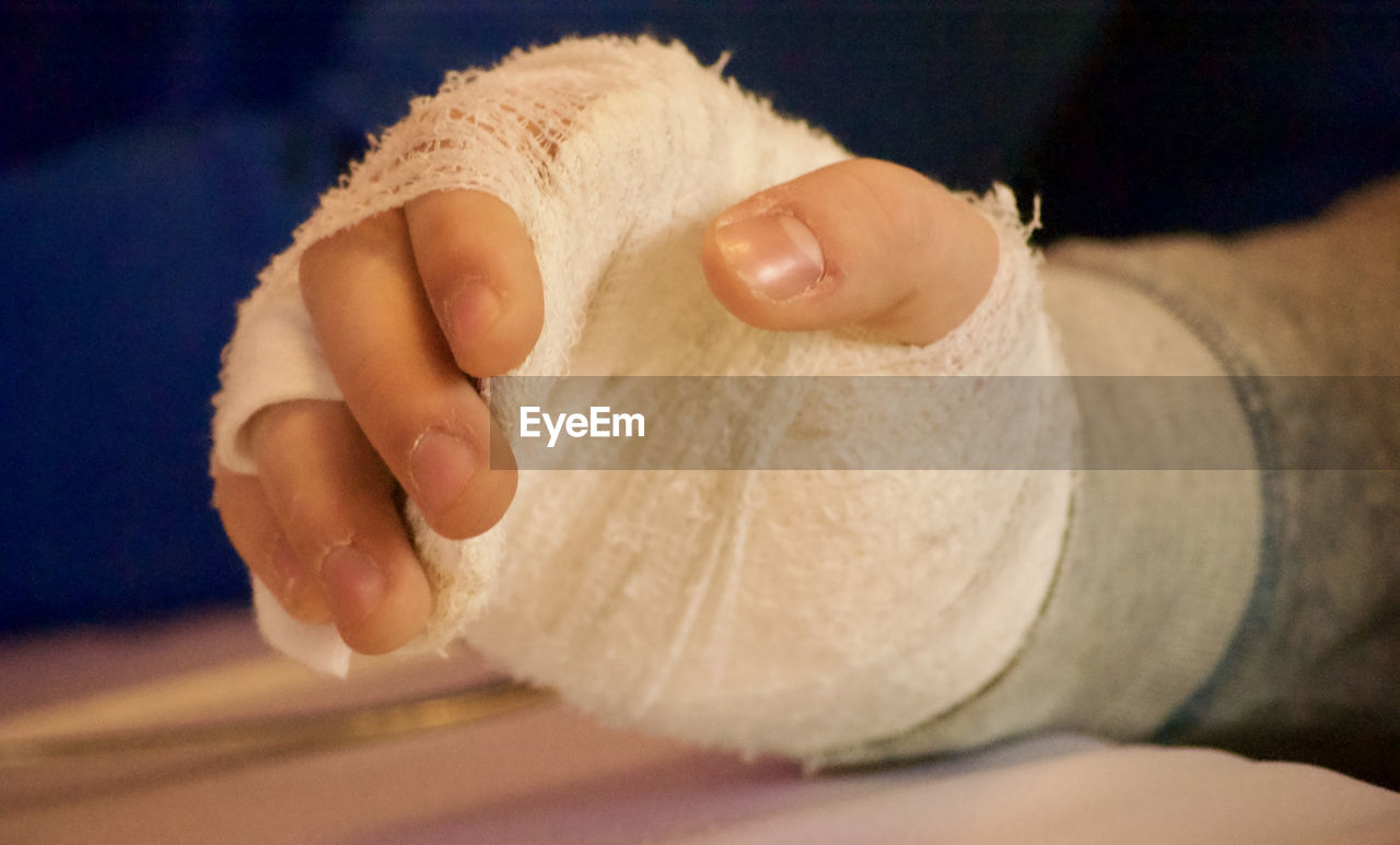 Cropped hand with bandages at table in hospital