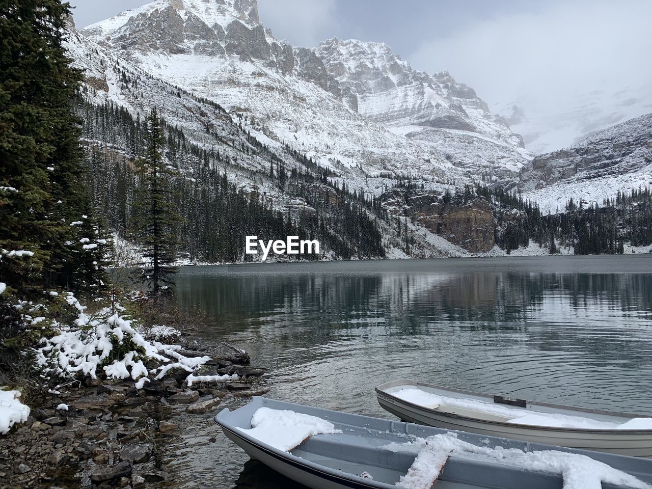 Early winter, boats on emerald green lake in mountains 