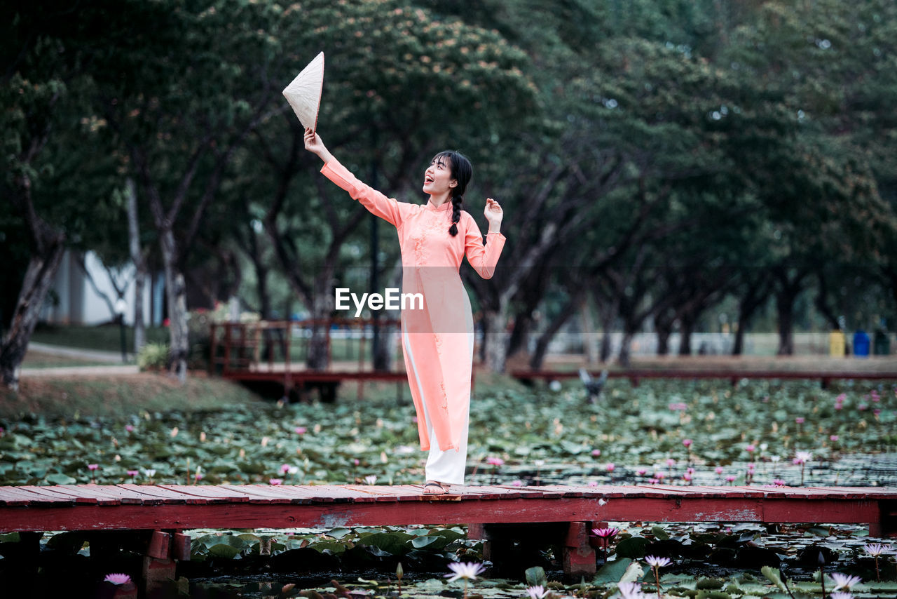 WOMAN STANDING BY PLANTS