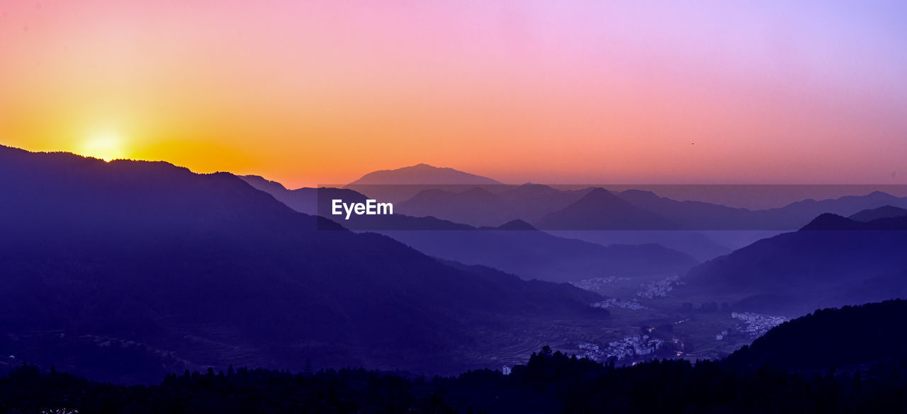 Scenic view of silhouette mountains against sky at sunset