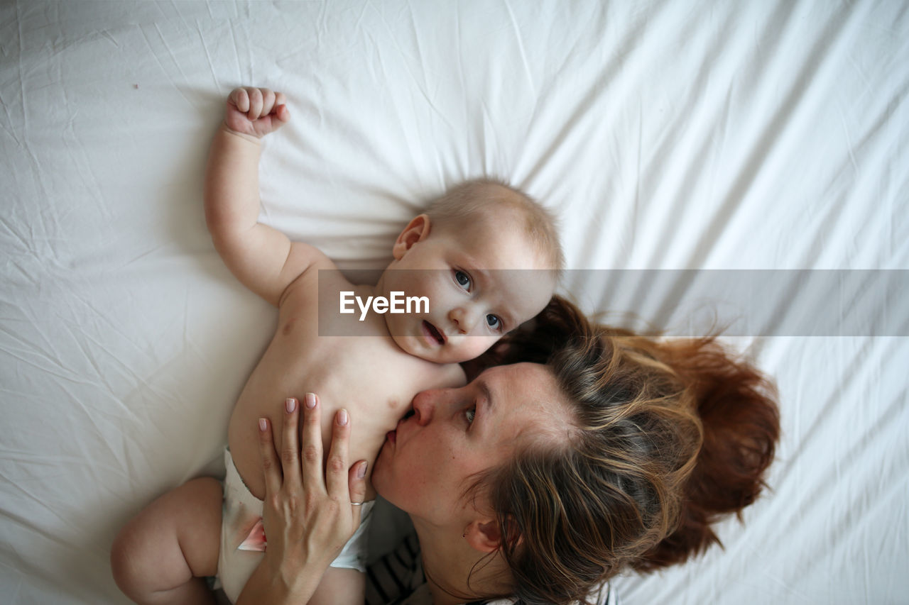 Mother gently hugs son, top view, white background. concept motherhood and emotions.