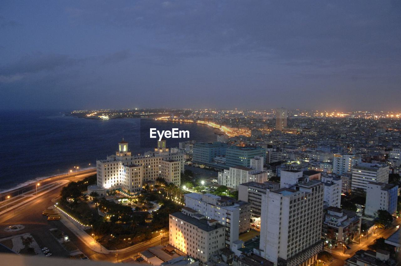 High angle view of illuminated cityscape against sky at night