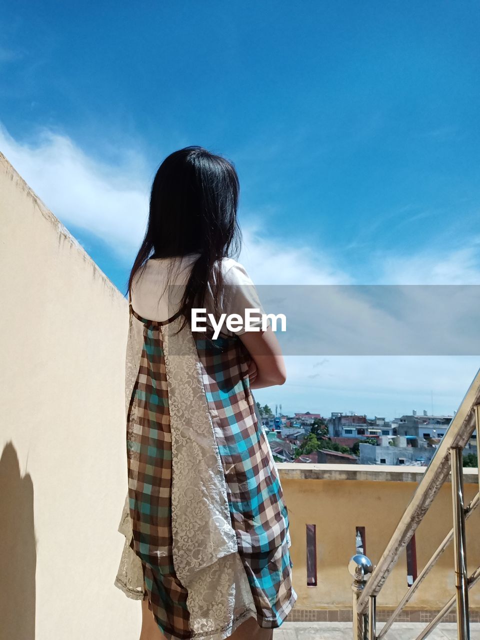 Rear view of woman standing against sky