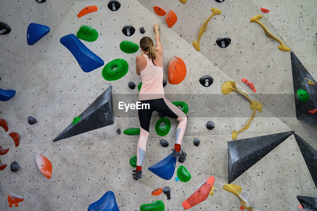 Woman training at bouldering gym. active recreation, sports exercises