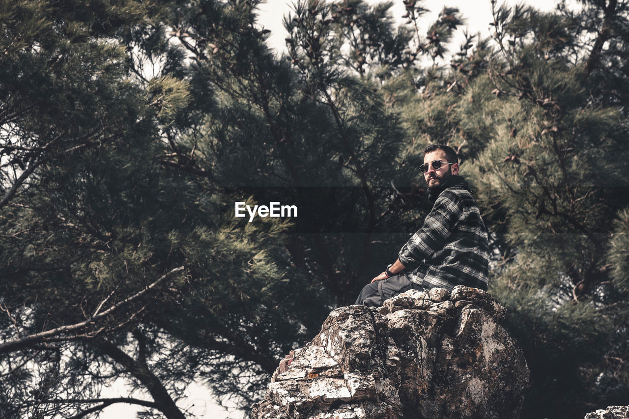 YOUNG MAN SITTING ON ROCK